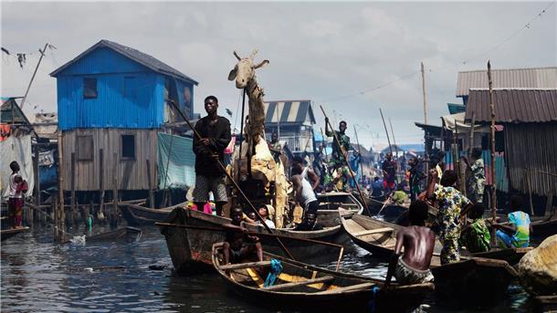 Auf Kanus bewegen sich die Puppenspieler durch Teile der Stadt Lagos im Land Nigeria. 