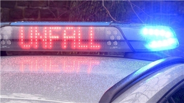 Das Blaulicht auf einem Fahrzeug der Polizei leuchtet in der Dunkelheit, während auf dem Display der Hinweis «Unfall» zu lesen ist.  Am Mittwoch gab es drei schwere Verkehrsunfälle im Cuxland. 