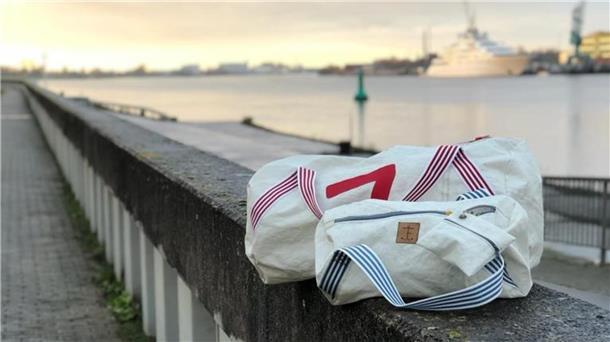 Zwei Taschen liegen auf einer Mauer