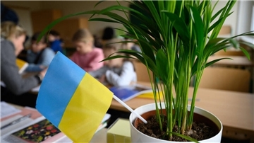 Grundschüler aus der Ukraine sitzen in einem Klassenzimmer.
