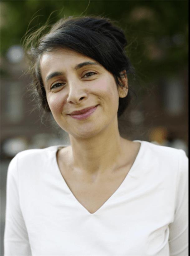 Eine Frau mit dunklen Haaren und einem weißen Shirt lächelt. Es ist die Autorin Çigdem Akyol, die am 27. März zu einer Lesung in Bremerhaven kommt. 