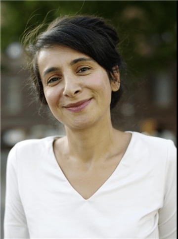 Eine Frau mit dunklen Haaren und einem weißen Shirt lächelt. Es ist die Autorin Çigdem Akyol, die am 27. März zu einer Lesung in Bremerhaven kommt. 