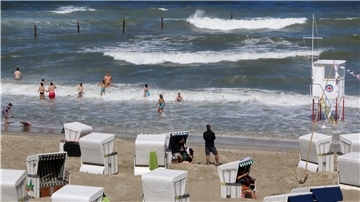 Badende stehen in den Wellen am Strand der Nordseeinsel.