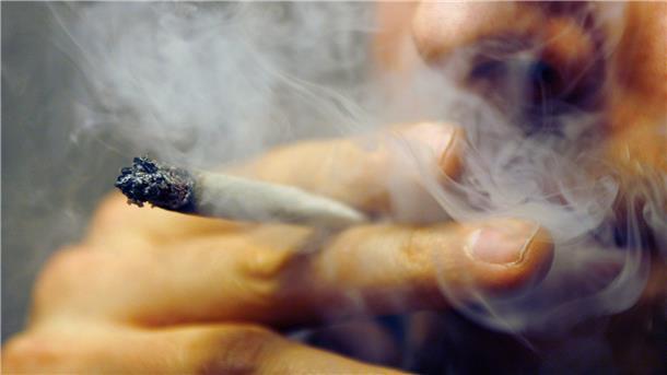 „Ein Dealer kontrolliert nicht den Ausweis“ Bald legal? Ein Mann zieht an einem Joint.
