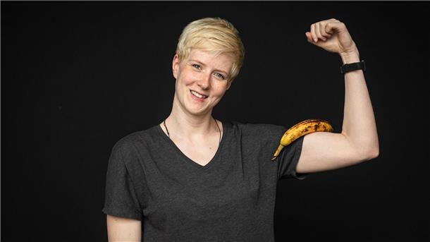Bananen-Power: Dein schneller Energiekick vor dem Sport Eine Frau mit einer Banane auf dem Arm.