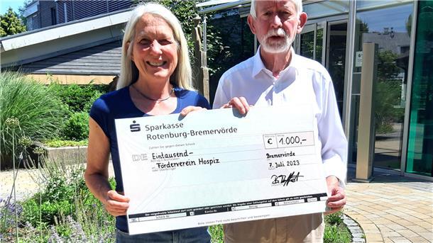 Barbara Treffert übergibt Ludwig Most einen symbolischen Scheck. Aus dem Verkauf von Fotos, die Andreas Dittmer aufgenommen hatte, fließen 1.000 Euro an das Hospiz in Bremervörde.