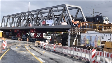 Bauen und Fahren: Während der Millimeterarbeit an den Stützpunkten rechts und links der hochgedrückten Brücke fährt auf dem Gleis des östlichen Brückenteils regulärer der Zugverkehr.