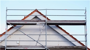 Baugerüst in einem Neubaugebiet. Die Zahl der Baugenehmigungen ist erneut gesunken.