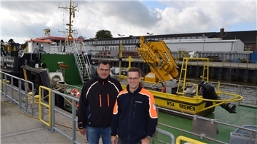 Bauhofleiter Chris Kreymborg (rechts) und sein Stellvertreter Stefan Schultz vor Arbeitsschiffen an der Kai- und Pontonanlage, die von Mitarbeitern des Bauhofes Brake gewartet werden.