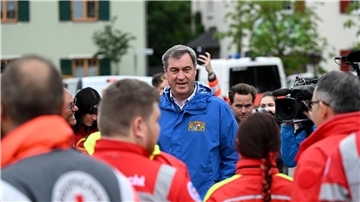 Bayerns Ministerpräsident Markus Söder (M, CSU), spricht zu Einsatzkräften vom Roten Kreuz, DLRG und anderen Rettungskräften bei einer Ortsbesichtigung im vom Hochwasser betroffenen oberbayerischen Reichertshofen.