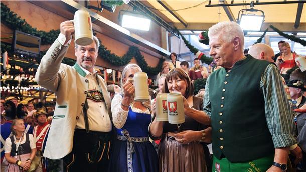190. Oktoberfest: „Gegen die Krisen der Welt“ Bayerns Ministerpräsident Söder (l.) und Münchens OB Reiter (r.) stoßen mit ihren Ehefrauen auf eine friedliche Wiesn an.