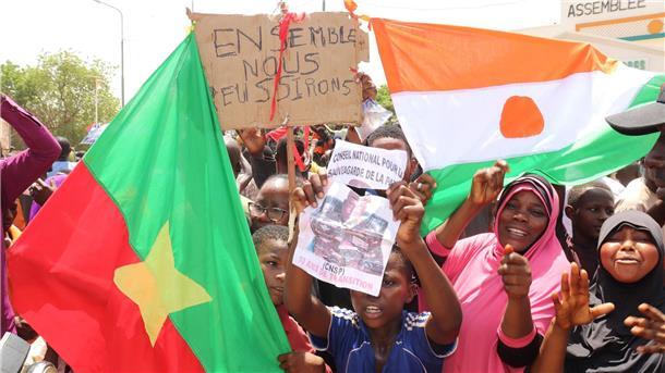 Niger schließt Militärpakt mit Burkina Faso und Mali Befürworter des Putschs halten eine Flagge von Burkina Faso (l) und Niger hoch. Die beiden Länder haben einen Pakt geschlossen.