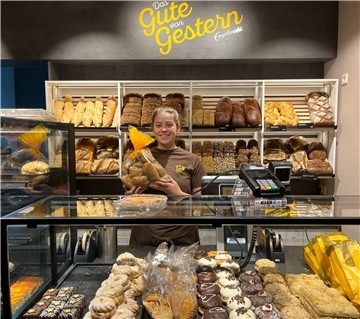 Verkäuferin in einer Bäckerei hinter dem Tresen