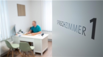 Ein Hausarzt sitzt in einem Sprechzimmer seiner Hausarztpraxis an einem Schreibtisch und arbeitet am Computer. Bei den „Cuxland-Gesprächen“ in Loxstedt diskutieren Experten über die Zukunft der hausärztlichen Versorgung. Im Fokus steht die Neuausrichtung des Kassenärztlichen Notdienstes.