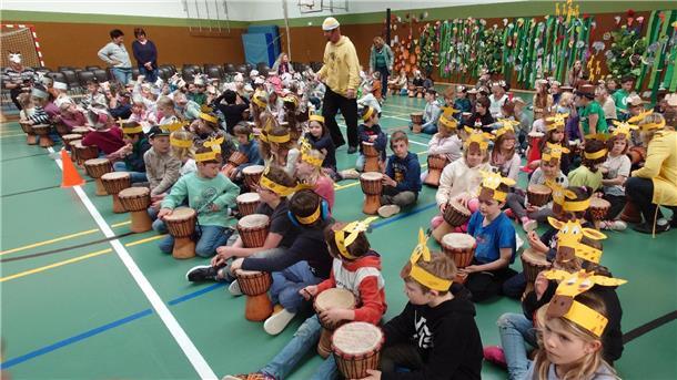 Kinder mit Kopfschmuck und Trommeln. An der Grundschule Butjadingen in Burhave fand eine Projektwoche zum Thema Afrika statt.