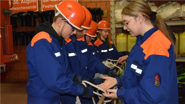 Das Foto zeigt den jugendlichen Feuerwehrnachwuchs beim Knotenbinden. 