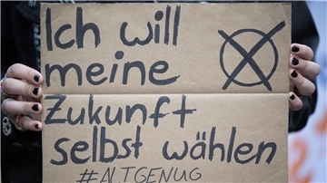 Eine Frau hält ein Plakat mit der Aufschrift "Ich will meine Zukunft selbst wählen".