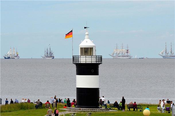 Ein Leuchtturm vor Segelschiffen