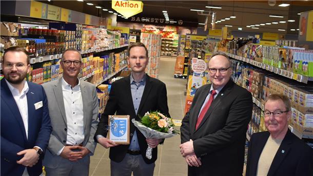 Fünf Männer stehen in einem neuen Supermarkt.