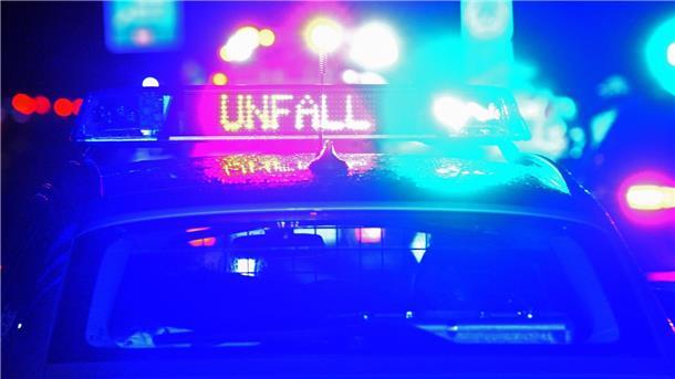 Ein Streifenwagen der Polizei steht mit Blaulicht an einer Unfallstelle.