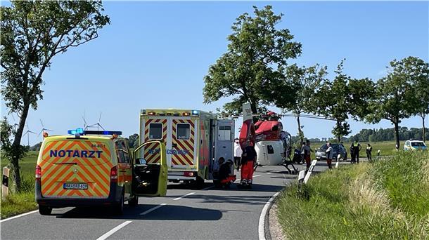 Rettungsfahrzeuge und ein Rettungshubschrauber auf einer Landesstraße in Butjadingen.