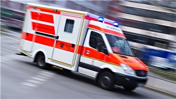 Ein Rettungswagen fährt mit Blaulicht. Bei einer Schlägerei in der Regionalbahn 33 erlitt ein Mann am Donnerstag Verletzungen am Kopf. Er wurde in ein Krankenhaus gebracht.