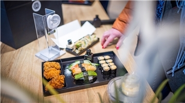 Eine Platte mit Sushi liegt auf einem Tisch.
