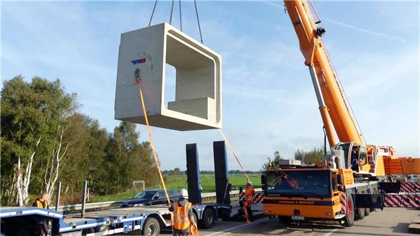 Bei Nordholz wird derzeit der Durchlass für den Altenbrucher Kanal erneuert. Dabei werden Betonteile durch die teilweise geöffnete Fahrbahn eingepasst. 