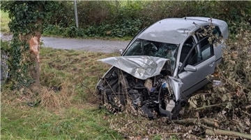 ein beschädigtes Auto steht nach einem Unfall teilweise in einem Graben