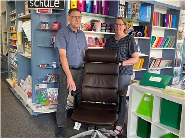 Mann und Frau mit Stuhl im Laden