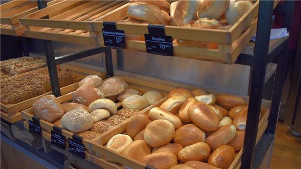 Hier gibt es am Feiertag in Zeven und Umgebung frische Brötchen Brötchen in Holzkisten in Regalen.