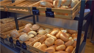 Brötchen in Holzkisten in Regalen.