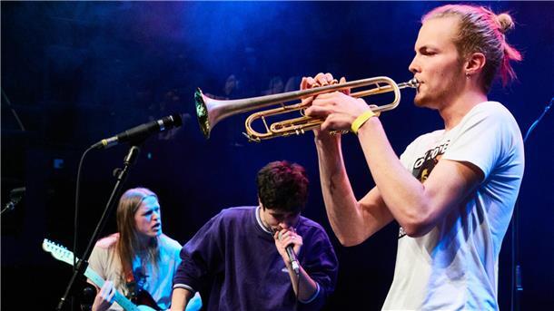 Drei Schüler musizieren und singen auf der Bühne im Bremer Schlachthof