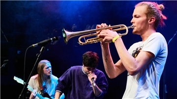 Drei Schüler musizieren und singen auf der Bühne im Bremer Schlachthof