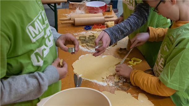Das Foto zeigt Kinder beim Plätzchen backen. 