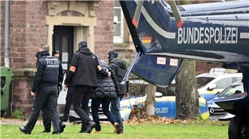 Beim Bundesgerichtshof in Karlsruhe wird eine Person von Polizisten aus einem Hubschrauber gebracht.