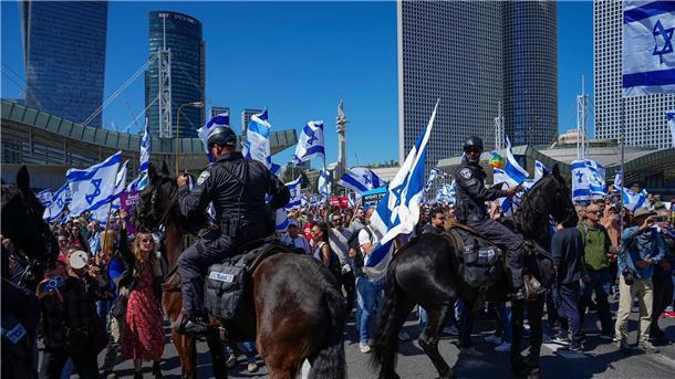 Berittene Polizisten werden eingesetzt, als Israelis eine Hauptstraße blockieren, um gegen die Pläne der Regierung von Ministerpräsident Netanjahu zu protestieren.