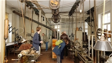 Besucherinnen und Besucher schauen sich in einer alten Werkstatt aus dem Jahr 1936 um. 