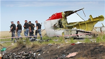 Bewaffnete Separatisten im Juli 2014 neben einem Trümmerteil der Malaysia-Airlines-Maschine im Osten der Ukraine.