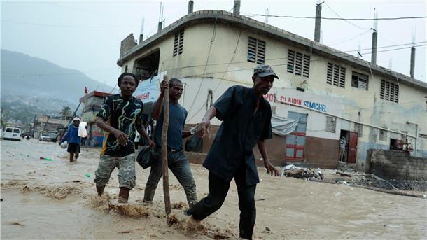 Haiti: 51 Todesopfer nach Überschwemmungen Bewohner waten über eine überschwemmte Straße nach einem starken Regen in Port-au-Prince.