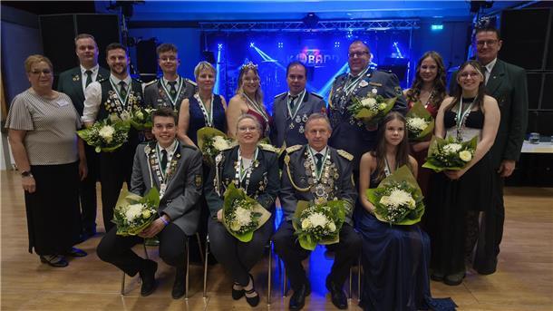 Bezirkspräsident Thomas Brunken (rechts), seine Stellvertreterin Renate Viebrock und sein Stellvertreter Sascha Denz mit der Bezirkskönigsfamilie 2025/26.
