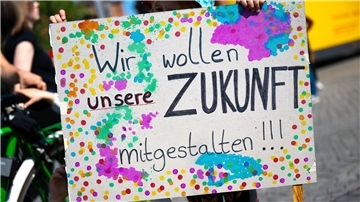 Jugendliche halten ein Plakat