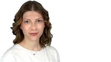 Eine Frau schaut in die Kamera und lächelt. 