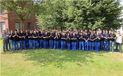 Auf dem Foto sind alle 57 Auszubildenden in drei Reihen abgebildet. 