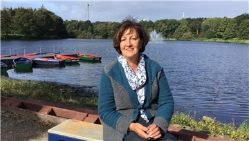 Eine Frau sitzt an einem See