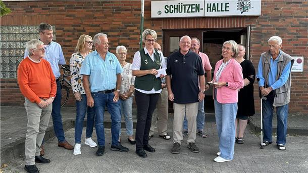 Mehrere Menschen bei einer Spendenübergabe vor dem Eingang der Schützenhalle