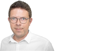 Mann mit weißem Hemd und Brille.