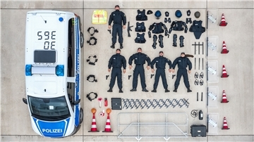 Neben einem Polizeiauto sind alle Gegenstände ordentlich aufgereiht.