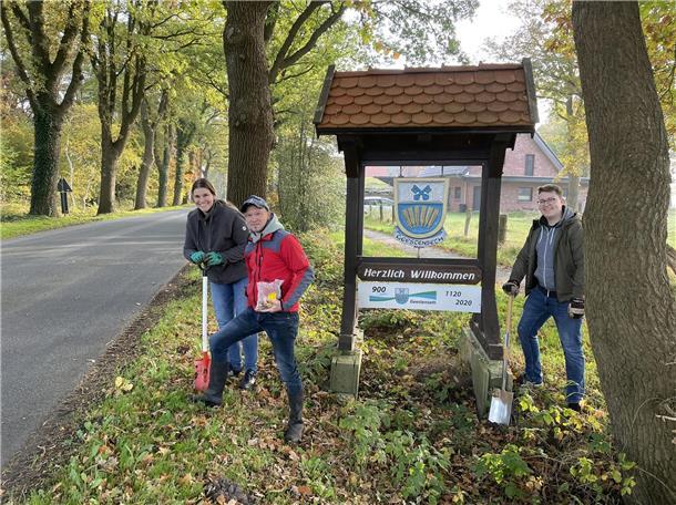 Geestenseth blüht im Frühjahr wieder auf Drei Männer an einer Straße mit einem Schild
