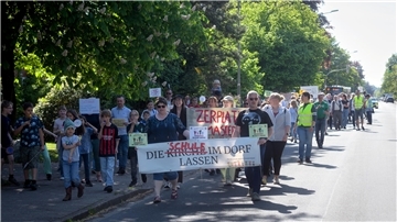 Menschen protestieren mit Schildern.
